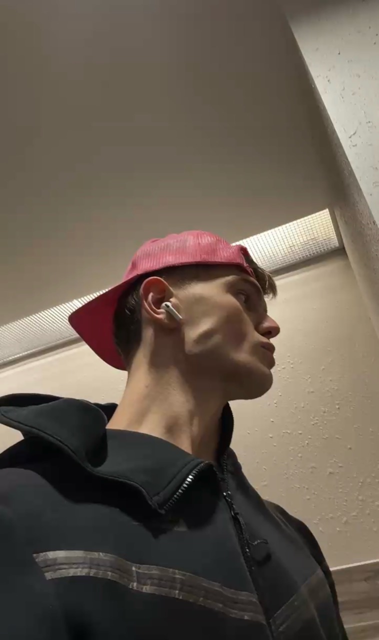 Side-profile portrait wearing a red cap
